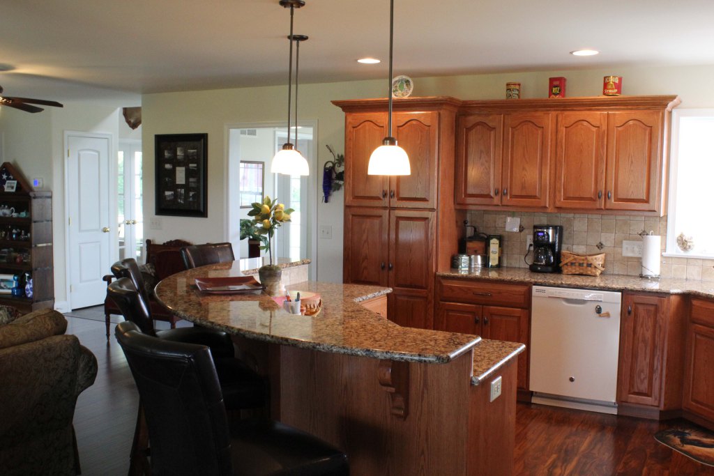 Exquisite open kitchen with curved breakfast/snack bar open to family room, hardwood flooring