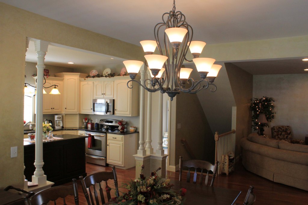 Open floor plan from dining room to kitchen has interior columns, hardwood floor, beautifully decorated