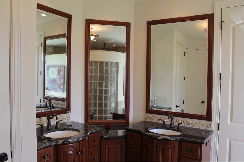 Gorgeous his and her vanities in lavish custom bathroom, tall mirrors over sinks